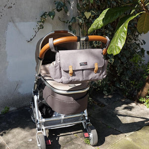 Storksak Travel Stroller Organiser Grey baby accessories on buggy outside | Travel baby accessories | Storksak - Award-winning Baby Changing Bags & Accessories
