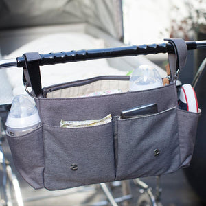 Storksak Travel Stroller Organiser Grey baby accessories open on buggy outside | Travel baby accessories | Storksak - Award-winning Baby Changing Bags & Accessories